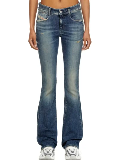 ג׳ינס, צבע כחול, גזרה צמודה עד הברכיים ואז מתרחבת, גזרה גבוהה יותר בצד האחורי